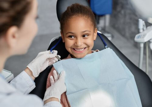 Child at dentist working with dental hygienists.